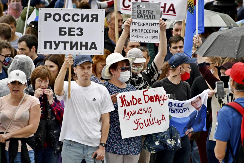 People holding posters that read: "Long Live Belarus, Lukashenka's Killer", "Russia without Putin" and "I'm, We're Sergei Furgal, Stop Repressions", during an unsanctioned protest in support of Sergei Furgal, the governor of the Khabarovsk region, in Khabarovsk, 6,100 kilometers (3,800 miles) east of Moscow, Russia, Saturday, Aug. 15, 2020. Thousands of demonstrators have again gathered in the major Russian Far East city of Khabarovsk to denounce the arrest of the region's governor a month ago and to support Belarusian people. (AP Photo/Igor Volkov)