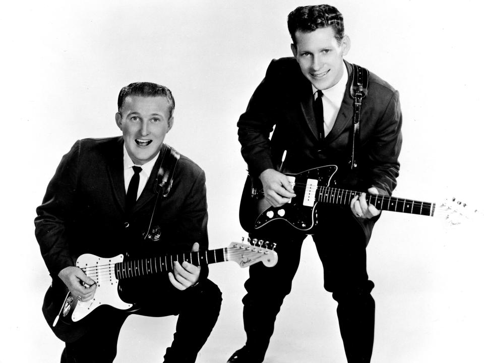 Don Wilson and Bob Bogle in suits holding electric guitars