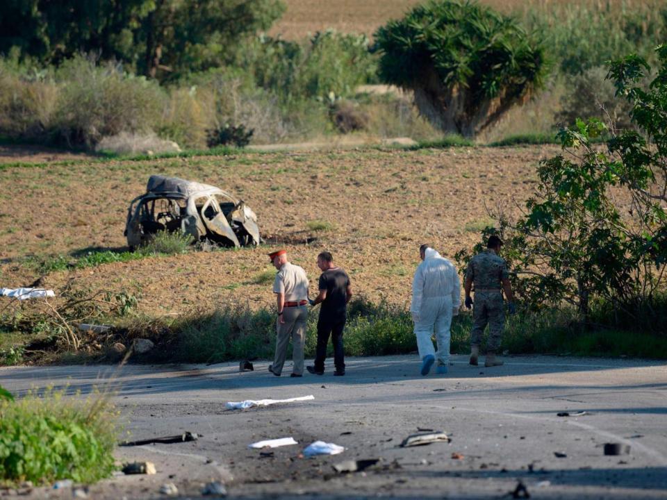 Police and forensic experts inspect the wreckage of a car bomb believed to have killed journalist and blogger Daphne Caruana Galizia close to her home in Bidnija, Malta (Getty)