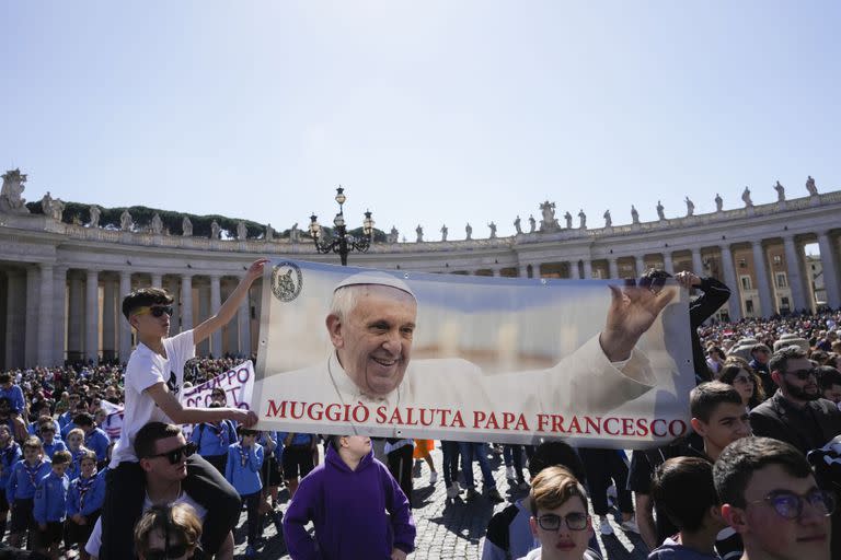 Fieles muestran una pancarta en la que se lee "Muggio saluda al Papa Francisco" durante la oración del Ángelus del mediodía desde la ventana de su estudio con vistas a la Plaza de San Pedro, en el Vaticano, el domingo 12 de marzo de 2023.