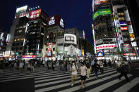 People walk along a pedestrian crossing Friday, July 30, 2021, in Tokyo, as Japanese Prime Minister Yoshihide Suga expanded a coronavirus state of emergency to four more areas in addition to Tokyo following record spikes in infections as the capital hosts the Olympics. (AP Photo/Eugene Hoshiko)