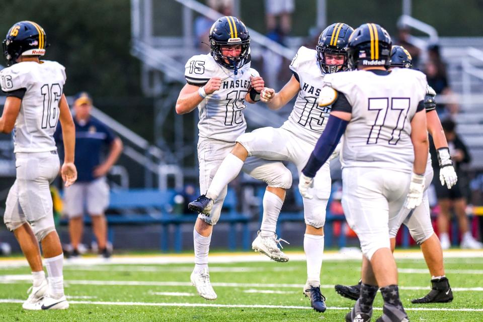 Haslett's Brody Quinn, left, celebrates his sack with teammate Colton Clark during the second quarter in the game against DeWitt on Thursday, Aug. 24, 2023, at DeWitt High School.