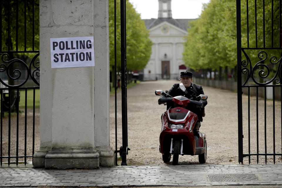 A Chelsea Pensioner drives his mobility scooter past a sign for a polling station after voting in London, Thursday, May 6, 2021. Millions of people across Britain will cast a ballot on Thursday, in local elections, the biggest set of votes since the 2019 general election. A Westminster special-election is also taking place in Hartlepool, England. (AP Photo/Matt Dunham)