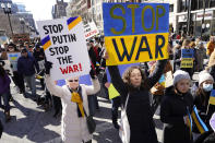 Demonstrators display placards as they march during a rally in support of Ukraine, Sunday, Feb. 27, 2022, in Boston. (AP Photo/Steven Senne)