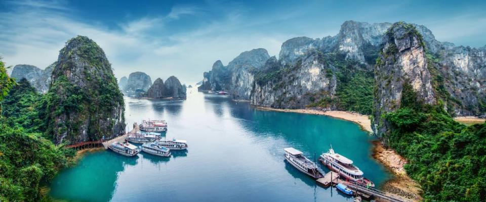 Tourist junks floating among limestone rocks at Ha Long Bay, South China Sea, Vietnam, Southeast Asia.