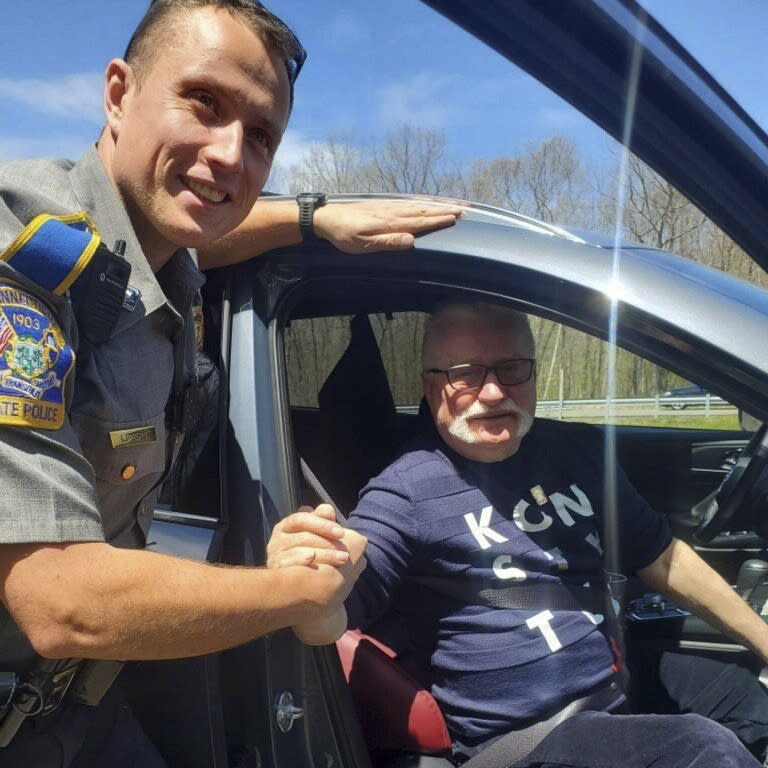 In this photo provided by the Connecticut State Police, Trooper Lukasz Lipert shakes hands with former Polish President Lech Walesa on Interstate 84 in Tolland, Conn., on Wednesday, May 11, 2022. State police said Lipert responded to the call of an SUV with a flat tire, and was greeted by Walesa, who had spoken in Hartford on Tuesday as part of his U.S. tour advocating for aid for refugees who have fled Ukraine during the war with Russia. (Connecticut State Police via AP)