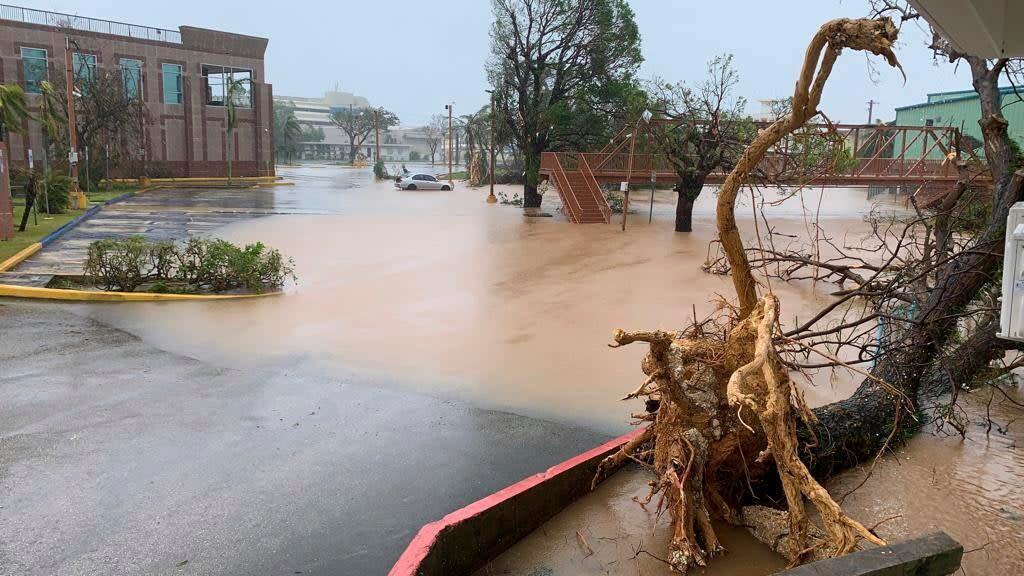 The waters of the Hagatna River overflows it's banks and encroaches into the Bank of Guam parking lot in Hagatna, Guam (AP)