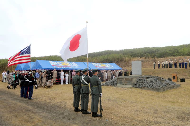 FILE PHOTO: The flags of U.S. and Japan are hoisted as participants attend a memorial service to mark the 70th anniversary of one of World War II's battles on the remote island of Iwo Jima