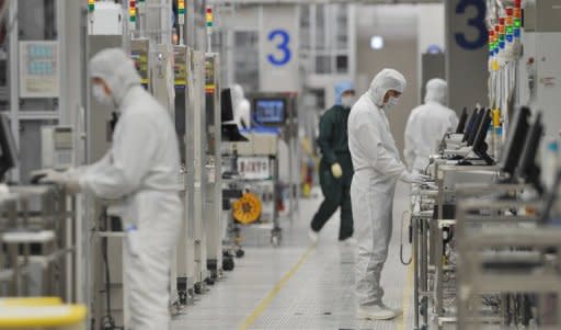 This file photo shows employees of Japan's microprocessor maker Renesas Electronics working at the company's Naka wafer factory in Hitachinaka, Ibaraki prefecture, in 2011. Renesas plans to cut 6,000 jobs, or about 15 percent of its workforce, as it struggles to turn a profit, Japan's biggest daily reported on Tuesday