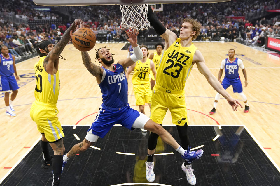 Los Angeles Clippers guard Amir Coffey (7) has the ball knocked from his hands by Utah Jazz guard Jordan Clarkson (00) as forward Lauri Markkanen (23) defends during the first half of an NBA basketball game Monday, Nov. 21, 2022, in Los Angeles. (AP Photo/Mark J. Terrill)