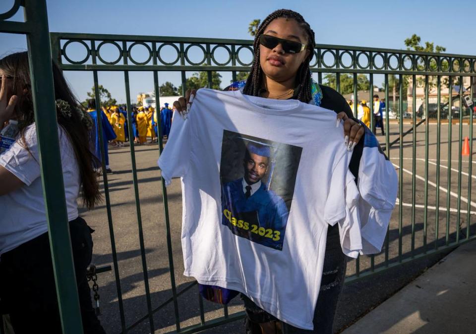 Jianna Smith, a 2022 John F. Kennedy High School graduate, holds a shirt dedicated to Billy Scott before the Grant Union High School graduation ceremony Thursday, June 1, 2023, in Sacramento’s Del Paso Heights neighborhood. Scott, an 18-year-old senior set to graduate, was killed in a North Highlands shooting the night before, authorities said.