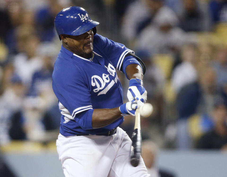 Los Angeles Dodgers' Juan Uribe hits a single to score Corey Seager against the Los Angeles Angels during the sixth inning of an exhibition baseball game in Los Angeles, Friday, March 28, 2014. (AP Photo/Danny Moloshok)