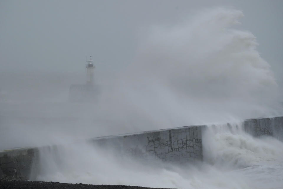 Waves crash over the harbour wall by a lighthouse as Storm Ciara hits Newhaven, on the south coast of England, Sunday, Feb. 9, 2020. Trains, flights and ferries have been cancelled and weather warnings issued across the United Kingdom and in northern Europe as the storm with winds expected to reach hurricane levels batters the region. (AP Photo/Matt Dunham)