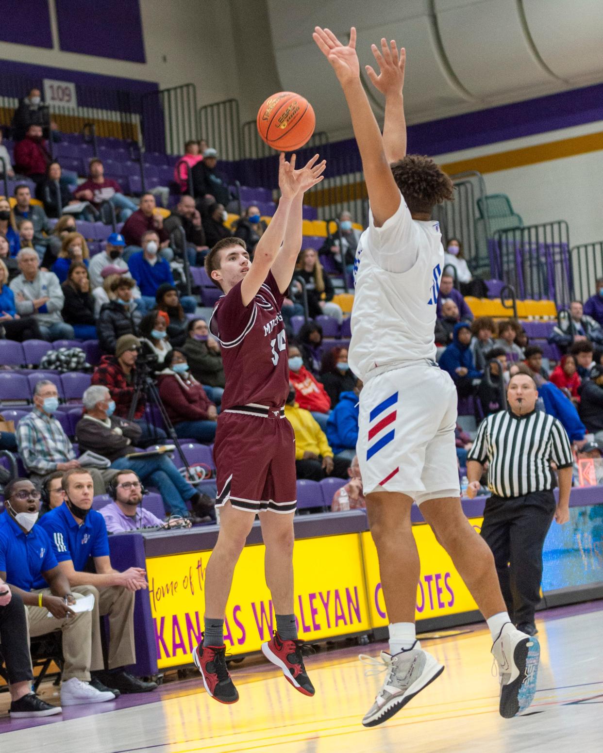 Salina Central's Ethan Waters (34) shoots over Andover's Devon Neal-McFarthing in the semifinals of the Salina Invitational Tournament at Mabee Arena on Friday. The Trojans won, 62-58.