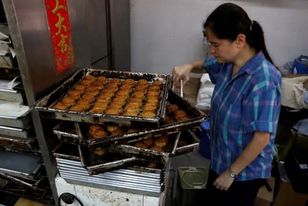 An employee picks anti-extradition mooncakes with slogans at Wah Yee Tang Bakery in Hong Kong