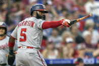 Washington Nationals'Josh Harrison (5) gestures at home plate with Gerardo Parra's bat after he scored on an RBI-single by Parra during the fourth inning of a baseball game against the Philadelphia Phillies, Monday, July 26, 2021, in Philadelphia. (AP Photo/Laurence Kesterson)