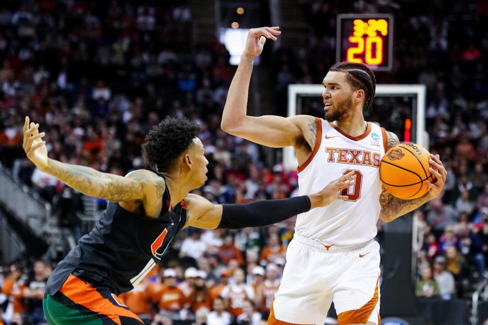 Texas forward Timmy Allen, right, controls the ball against Miami Hurricanes guard Jordan Miller in the first half at the Midwest Region final at T-Mobile Center in Kansas City, Mo. Allen has 10 points as Texas entered halftime with a 45-37 lead..