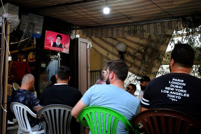 Lebanese supporters of pro-Iranian Hezbollah listen to a televised speech of the party leader Hassan Nasrallah at a cafe in Beirut. Nasrallah said the pager attack which has killed 37 people and injured thousands crossed a 'red line' as fears of a wider war mount. Marwan Naamani/ZUMA Press Wire/dpa