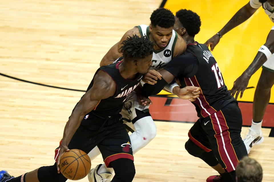 Miami Heat forward Jimmy Butler, left, drives to the basket as center Bam Adebayo (13) applies a pick against Milwaukee Bucks forward Giannis Antetokounmpo, center, during the first half of Game 4 of an NBA basketball first-round playoff series, Saturday, May 29, 2021, in Miami. (AP Photo/Lynne Sladky)