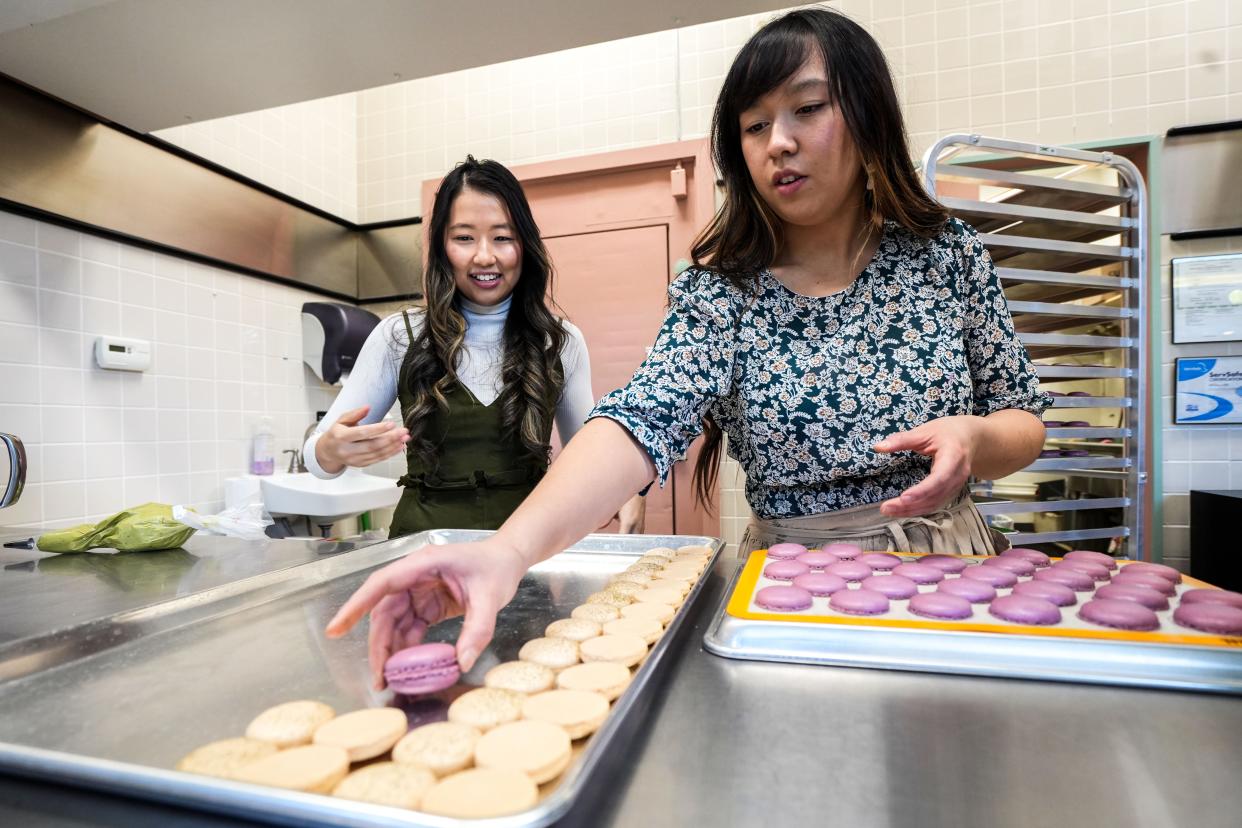 Bebe Lam, left, organizes macaron cookies with Anna Lam at Good Day, DSM in Valley West Mall.