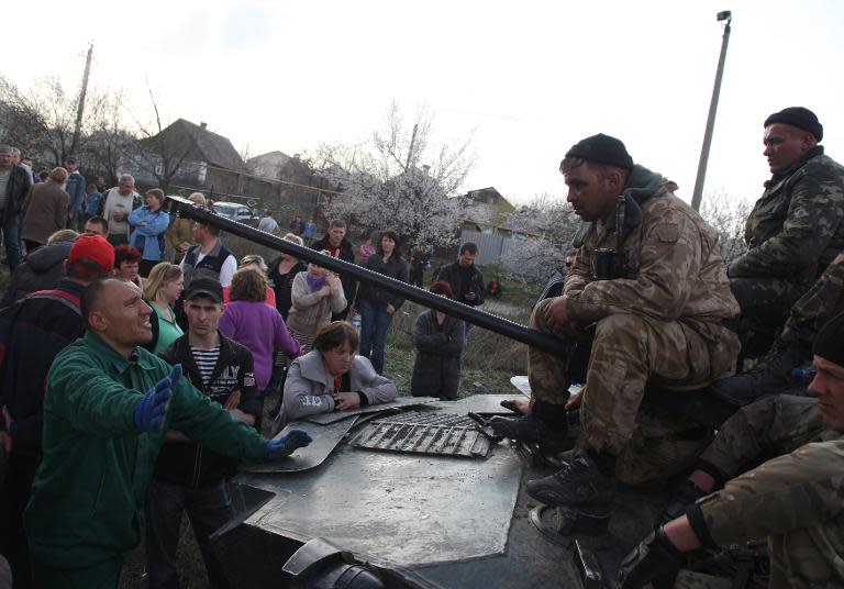 Ukrainians sit on armoured personnel carriers as they are blocked by armed pro-Russia supporters in the eastern Ukrainian city of Kramatorsk on April 16, 2014