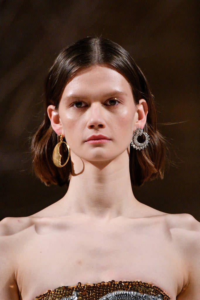 <p>Gold half moon hoop earring and silver crystal-encrusted earring at the Oscar de la Renta FW18 show. (Photo: Getty Images) </p>