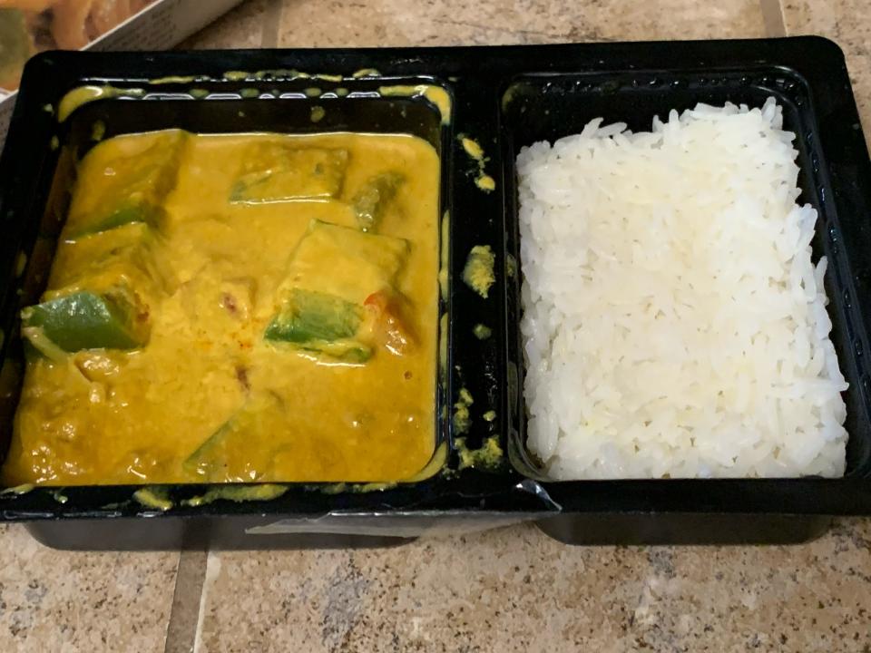 Cooked Trader Joe's yellow jackfruit curry in black microwavable package