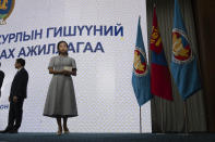 Tsenguun Saruulsaikhan, a young and newly minted member of Mongolia's parliament, holds up her Parliament membership card during a ceremony held at the Government Palace in Ulaanbaatar, Mongolia, Monday, July 1, 2024. Tsenguun was one of 42 winning candidates from the Democratic Party, the main opposition group, which made a major comeback after being reduced to a handful of seats in the 2016 and 2020 elections. (AP Photo/Ng Han Guan)