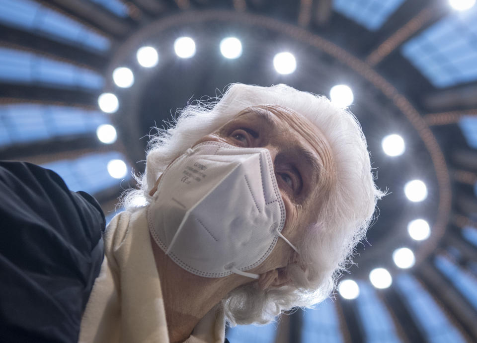 CORRECTS MONTH TO JANUARY - After receiving her vaccination against the novel coronavirus, 90-year-old Odores H. sits under the domed roof of the vaccination centre in the Festhalle in Frankfurt, Tuesday, Jan. 19, 2021. This is where thousands of people usually gather for concerts and trade fairs, and where the state of Hesse operates one of its vaccination centers. (Boris Roessler/dpa via AP)