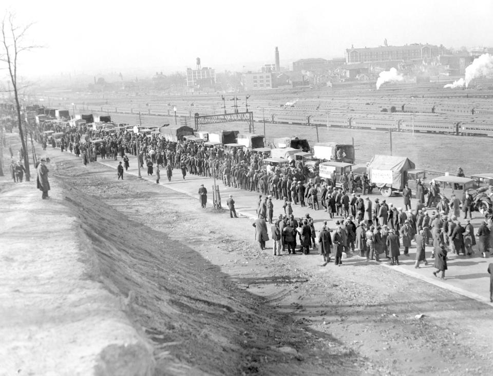 FILE - In this Dec. 5, 1932, file photo, a general view as the nearly 2,500 demonstrators, cold and cramped from a night spent in their trucks and automobiles, assembled in line for their food rations at their encampment on the outskirts of Washington. Nearly a century later, the U.S. economy is all but shut down, and layoffs are soaring at small businesses and major industries. A devastating global recession looks inevitable. Deepening the threat, a global oil price war has erupted. Some economists foresee an economic downturn to rival the Depression. (AP Photo)