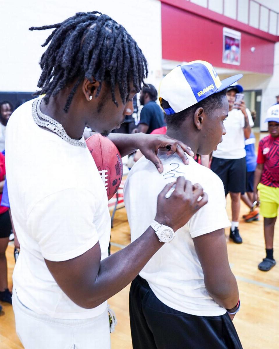 Derion Kendrick signs the back of a camper’s shirt at his youth camp at South Pointe High School. (Shot by KendraShotit)