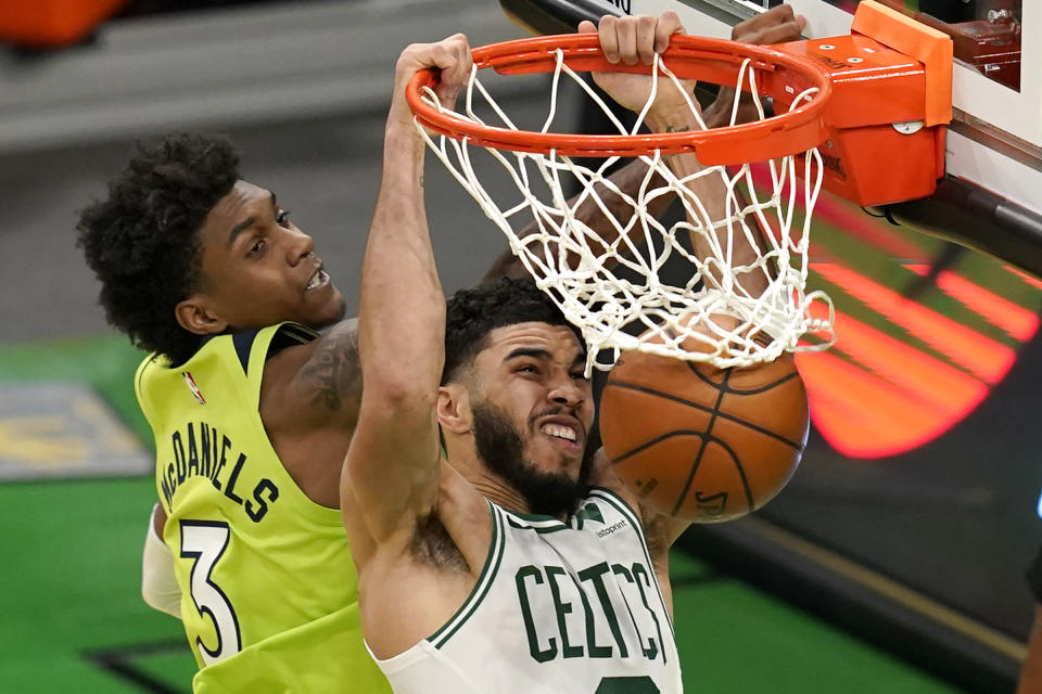 Boston Celtics forward Jayson Tatum, right, dunks against Minnesota Timberwolves forward Jaden McDaniels (3) in the third quarter of an NBA basketball game, Friday, April 9, 2021, in Boston. (AP Photo/Elise Amendola)