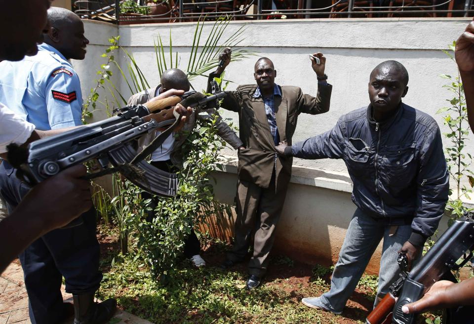 Policemen search a man for weapons as he walked out of Westgate Shopping Centre in Nairobi September 21, 2013. Militant gunmen stormed the shopping mall in Nairobi on Saturday killing at least 39 people, including children, and sending scores fleeing into shops, a cinema and onto the streets in search of safety. Kenyan security forces were still locked in a standoff on Sunday with the al Qaeda-linked militants, who were holding an unknown number of hostages. Picture taken September 21, 2013. REUTERS/Goran Tomasevic (KENYA - Tags: CIVIL UNREST)