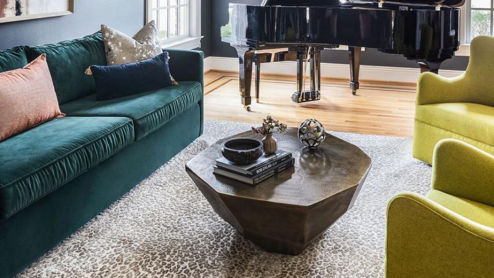 a living room with green sofa and lime green arm chairs and a black piano