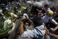 <p>Manifestantes opositores se enfrentan a integrantes de la Policía Nacional Bolivariana (PNB) durante una manifestación hoy, martes 4 de abril de 2017, que intentaba marchar hacia el Parlamento en apoyo a la destitución de los magistrados del Supremo, en Caracas (Venezuela). La Guardia Nacional Bolivariana de Venezuela (GNB, policía militar) disolvió hoy con gases lacrimógenos y perdigones de goma una manifestación de decenas de opositores que intentaban marchar hacia el Parlamento en apoyo a la destitución de los magistrados del Supremo, según constató Efe. EFE/CRISTIAN HERNÁNDEZ </p>