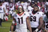 Georgia linebacker Jermaine Johnson (11) celebrates a win with a branch from the bushes at the stadium after the team's NCAA college football game against South Carolina on Saturday, Nov. 28, 2020, in Columbia, S.C. Georgia won 45-16. (AP Photo/Sean Rayford)