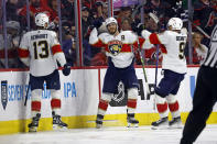Florida Panthers' Matthew Tkachuk (19) celebrates his game winning overtime goal with teammates Sam Reinhart (13) and Sam Bennett (9) following Game 2 of the NHL hockey Stanley Cup Eastern Conference finals against the Carolina Hurricanes in Raleigh, N.C., Saturday, May 20, 2023. (AP Photo/Karl B DeBlaker)