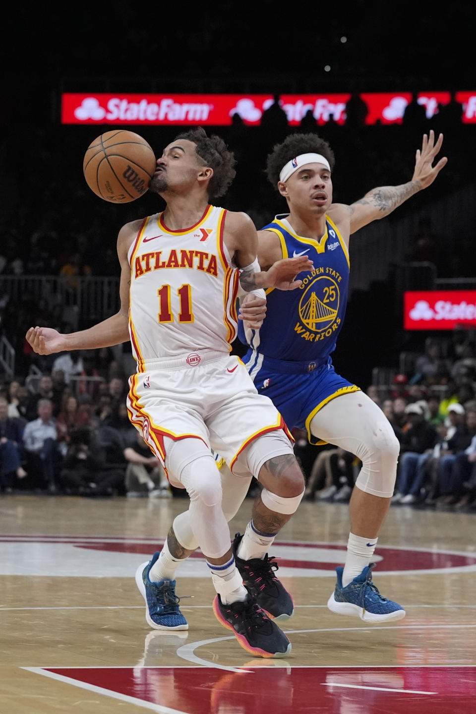Atlanta Hawks guard Trae Young (11) is fouled by Golden State Warriors guard Lester Quinones (25) as he drives to the basket in overtime in an NBA basketball game Saturday, Feb. 3, 2024, in Atlanta. (AP Photo/John Bazemore)