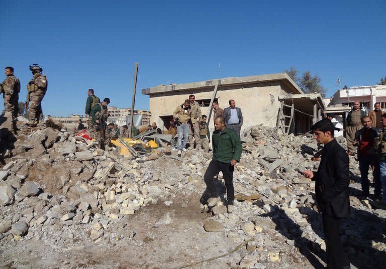 Local men and soldiers inspect the site of an explosion in Kirkuk, Iraq, on January 16, 2013