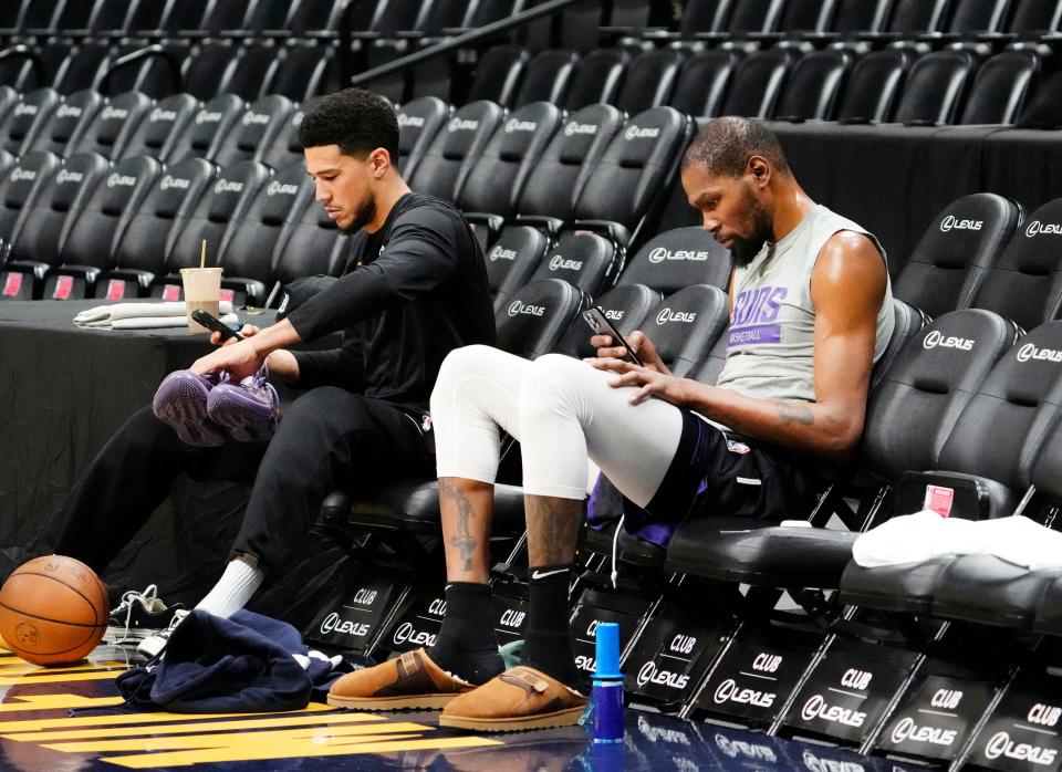 Phoenix Suns guard Devin Booker and forward Kevin Durant check their phones after Friday's practice in Denver on April 28, 2023, as the team prepares for the Western Conference Semifinals against the Denver Nuggets at Ball Arena.