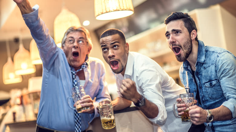 three men drinking and yelling