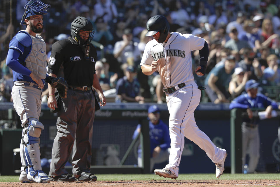 Seattle Mariners' Ty France crosses home on a bases-loaded walk as Kansas City Royals catcher Cam Gallagher waits during the fifth inning of a baseball game Saturday, Aug. 28, 2021, in Seattle. (AP Photo/Jason Redmond)