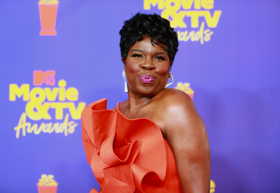 leslie at the mtv awards with a orange dress and smile