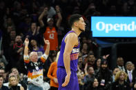 Phoenix Suns fans cheer on Suns guard Devin Booker after he scored against the Chicago Bulls during the second half of an NBA basketball game in Phoenix, Wednesday, Nov. 30, 2022. The Suns won 132-113. (AP Photo/Ross D. Franklin)