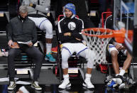 Golden State Warriors guard Stephen Curry, right, watches from the bench during the second half of an opening night NBA basketball game against the Brooklyn Nets, Tuesday, Dec. 22, 2020, in New York. (AP Photo/Kathy Willens)