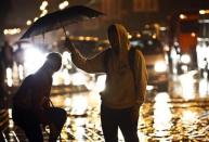 A couple shelter under an umbrella as it rains in Sochi, September 24, 2013. REUTERS/Maxim Shemetov