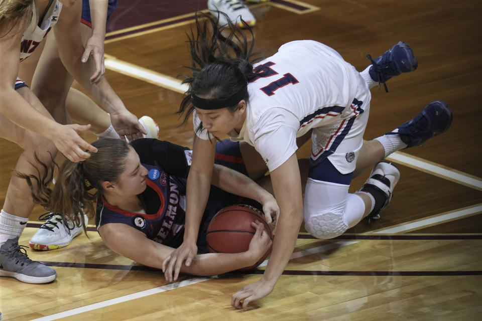 Gonzaga's Kaylynne Truong (14) battles Belmont's Jamilyn Kinney, bottom, for a loose ball during the first half of a college basketball game in the first round of the women's NCAA tournament at the University Events Center in San Marcos, Texas, Monday, March 22, 2021. (AP Photo/Chuck Burton)