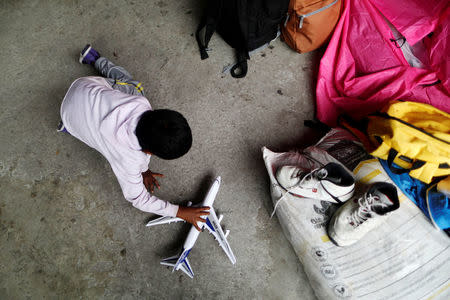 A boy, a member of a migrants caravan from Central America, plays with a toy aeroplane at the end of the caravan journey through Mexico, prior to preparations for an asylum request in the U.S., in Tijuana, Baja California state, Mexico April 26, 2018. REUTERS/Edgard Garrido