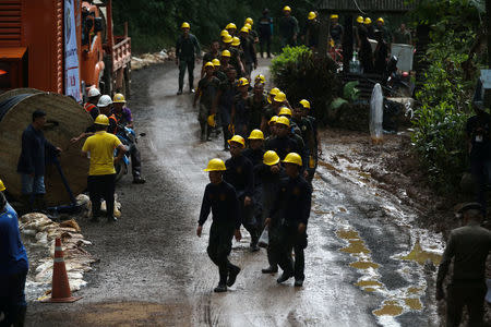 Military personnel walk in line as they prepare to enter the Tham Luang cave complex, where 12 boys and their soccer coach are trapped, in the northern province of Chiang Rai, Thailand, July 6, 2018. REUTERS/Athit Perawongmetha