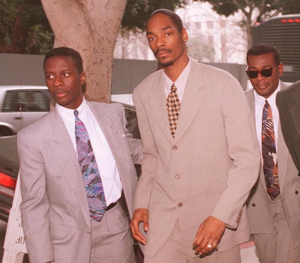 El cantante de rap Calvin Broadus (al centro), alias Snoop Doggy Dogg, siendo escoltado hasta el edificio de los Juzgados de lo Penal de Los Ángeles el viernes 9 de febrero de 1996, en donde él y un antiguo guardaespaldas están siendo juzgados por un asesinato cometido en 1993. Se espera que el fiscal del distrito termine hoy su alegato, tras lo cual el caso se le entregaría al jurado.